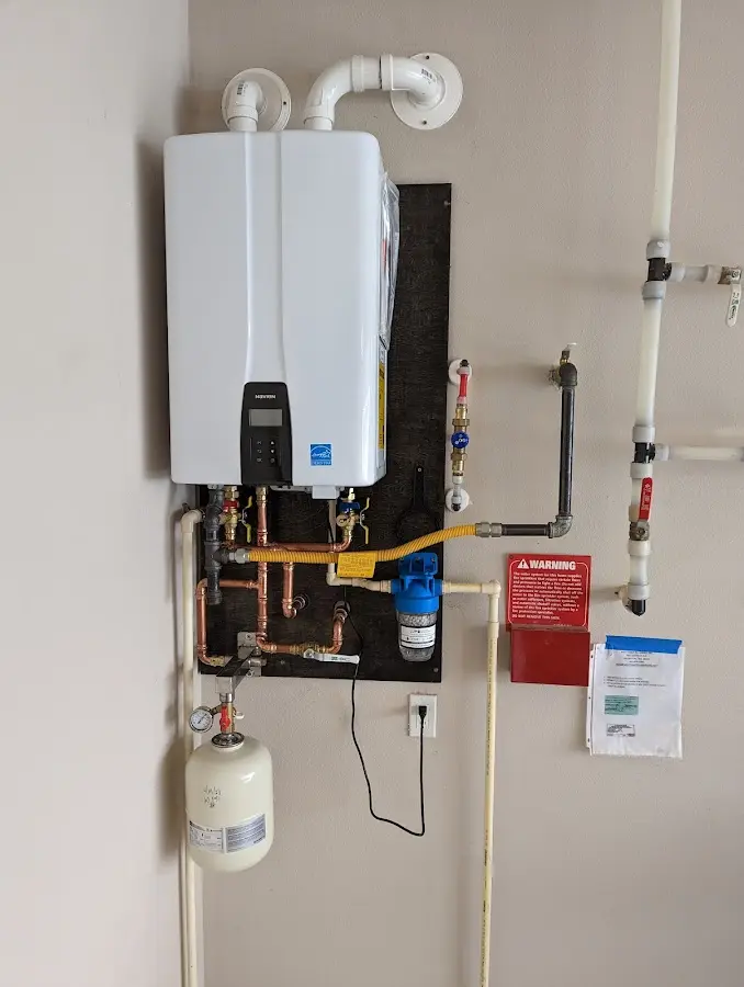 Professional plumber installing copper piping in a Copake home